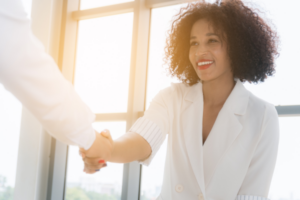 A photo of a woman shaking hands with someone else.