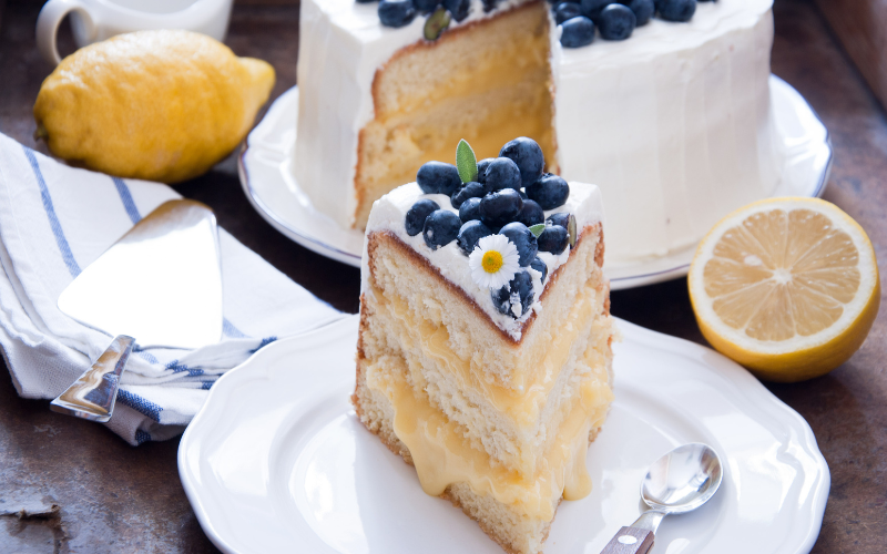 Blueberry Lemon Cake Slice with a full cake in the background