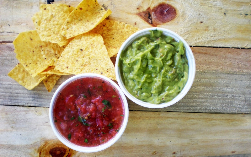 Chips surrounded by guac and mild salsa