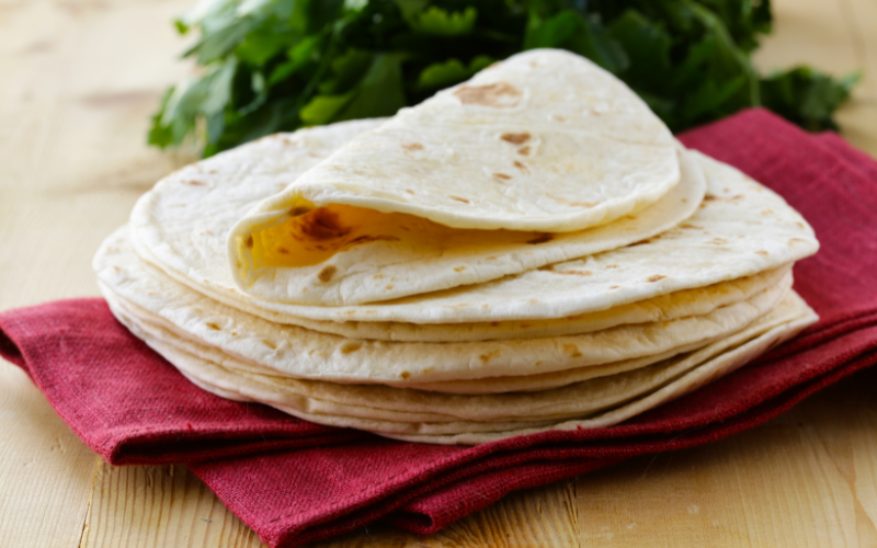 Corn tortillas made from corn flour, stacked together in a pile.