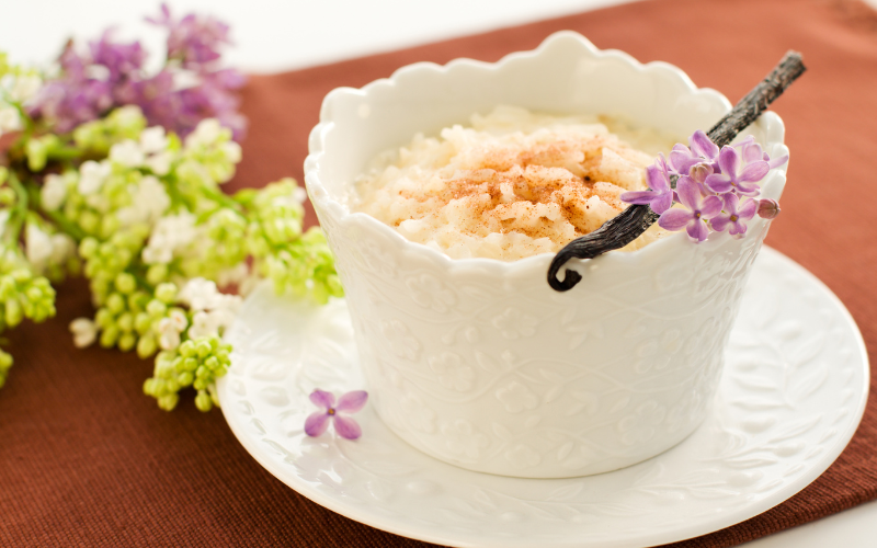 Creamy rice pudding served in a floral bowl on top of an intricate plate